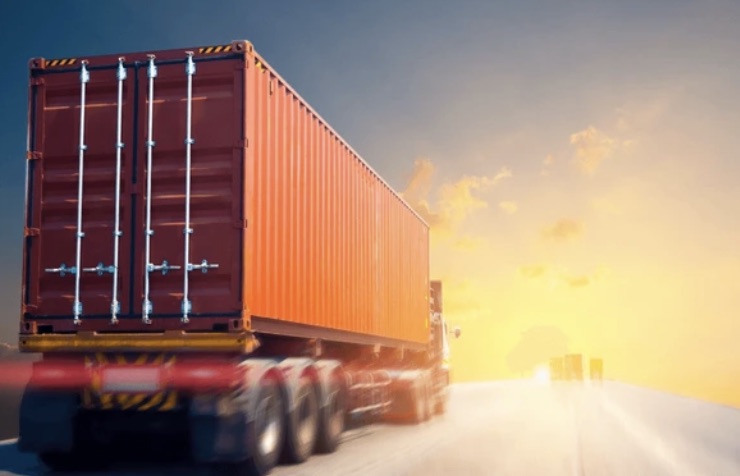 Camión con contenedor de carga en carretera al atardecer — comercio transfronterizo B2B entre México y EE.UU.